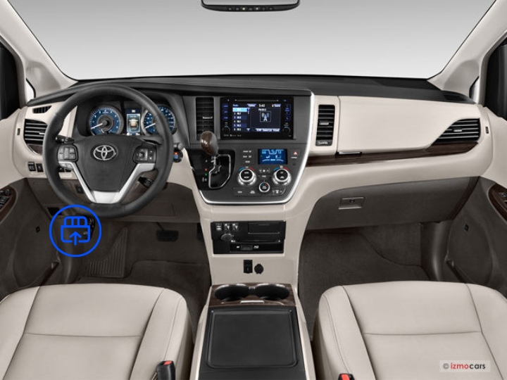  The image shows the interior of a Toyota Sienna, highlighting the OBD-II port location beneath the dashboard near the driver’s footwell.