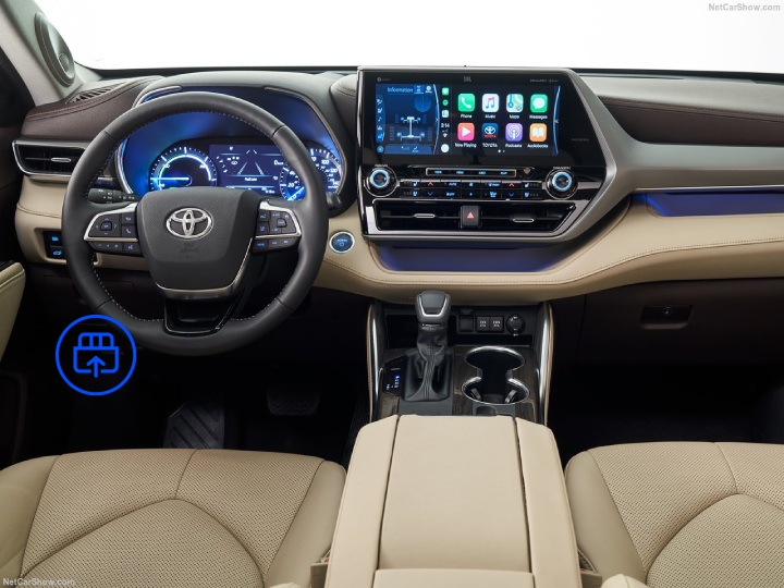  The image shows the interior of a Toyota Highlander, highlighting the OBD-II port location beneath the dashboard near the driver’s footwell.