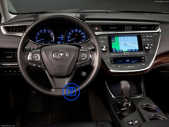  The image shows the interior of a Toyota Avalon, highlighting the OBD-II port location beneath the dashboard near the driver’s footwell.