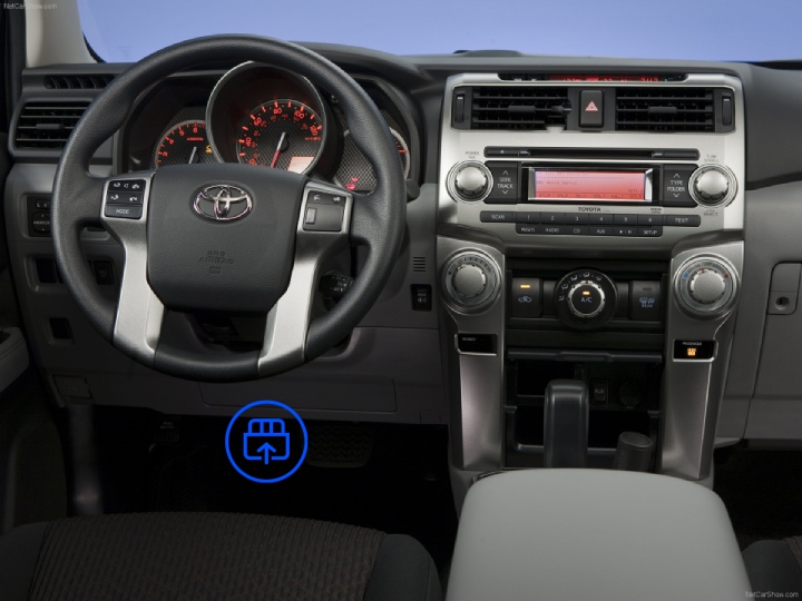  The image shows the interior of a Toyota 4Runner, highlighting the OBD port location beneath the dashboard, near the driver's footwell.